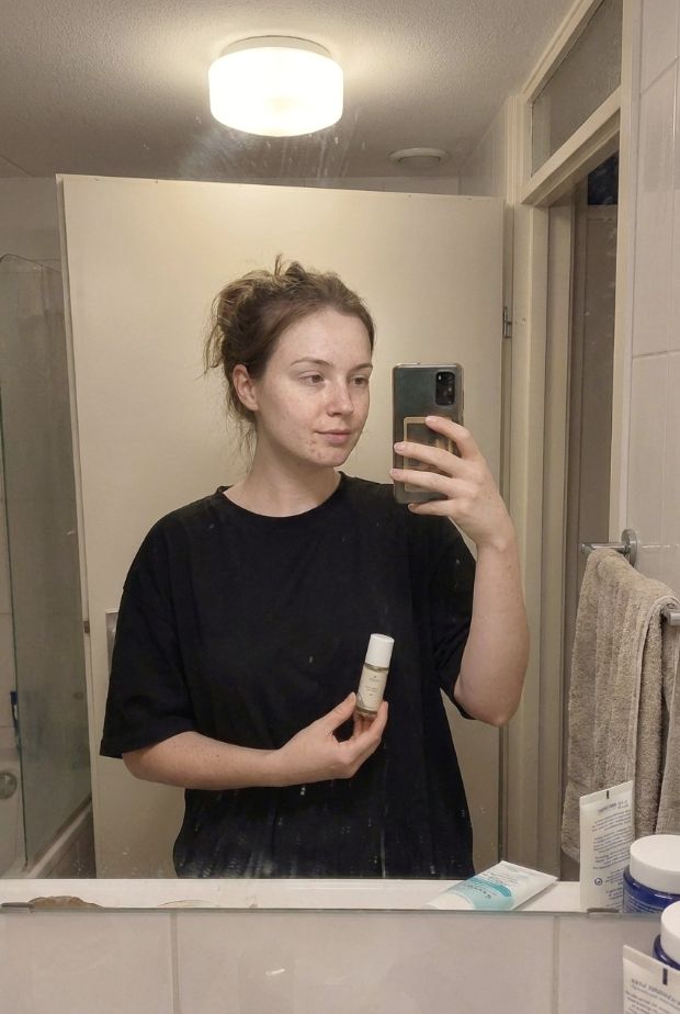 A customer holding the Kastor roller in the bathroom mirror