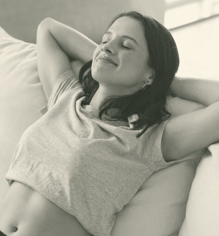 A woman resting on her sofa after using the Kastor roller
